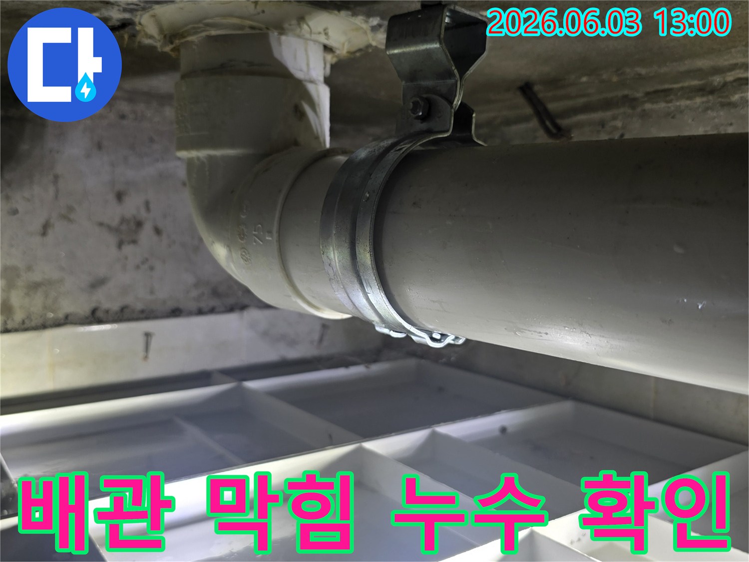 배관 막힘으로 인한 누수 여부를 확인하기 위해-배수관의 연결 부위와-벽면 상태를 점검하는 이미지입니다