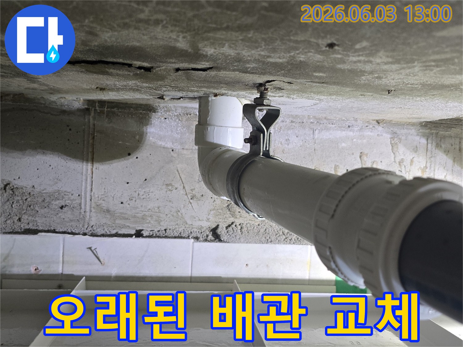 콘크리트 벽에 새로운 배관이 견고하게 설치된-오래된 배관 교체 현장입니다.