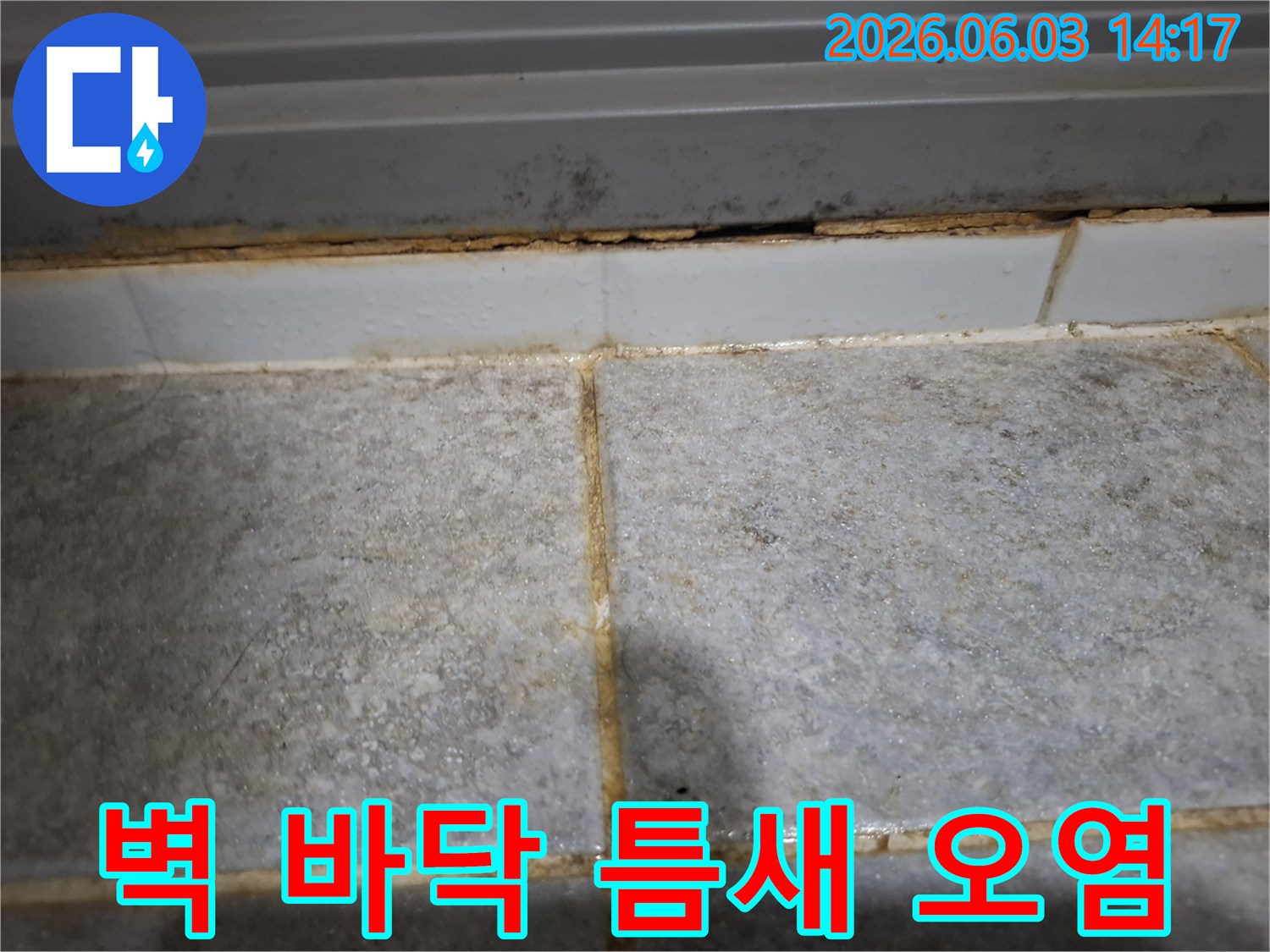 벽과 바닥 사이 틈새에 심각한 오염과 부식이 발생하여-누수가 장기간 진행되었음을 보여줍니다