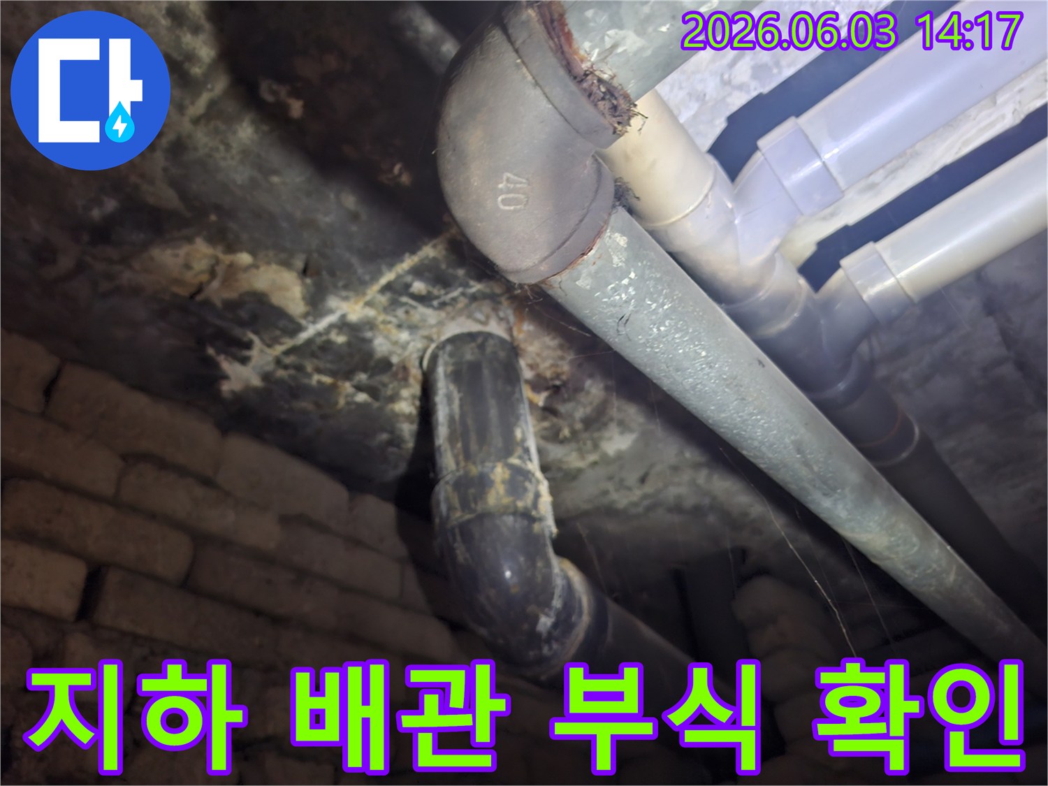 지하 공간의 노후된 배관에서-부식으로 인한 물샘 흔적을-꼼꼼히 점검하는 모습