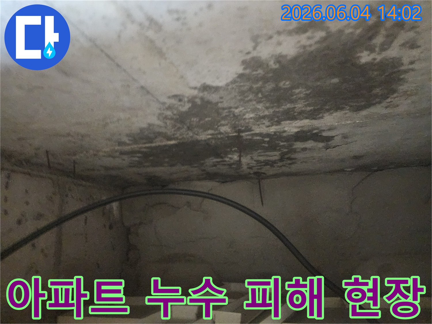 아파트 아래층 천장에 발생한-누수로 인한-심각한 물자국과-콘크리트 손상을 담은 사진입니다.