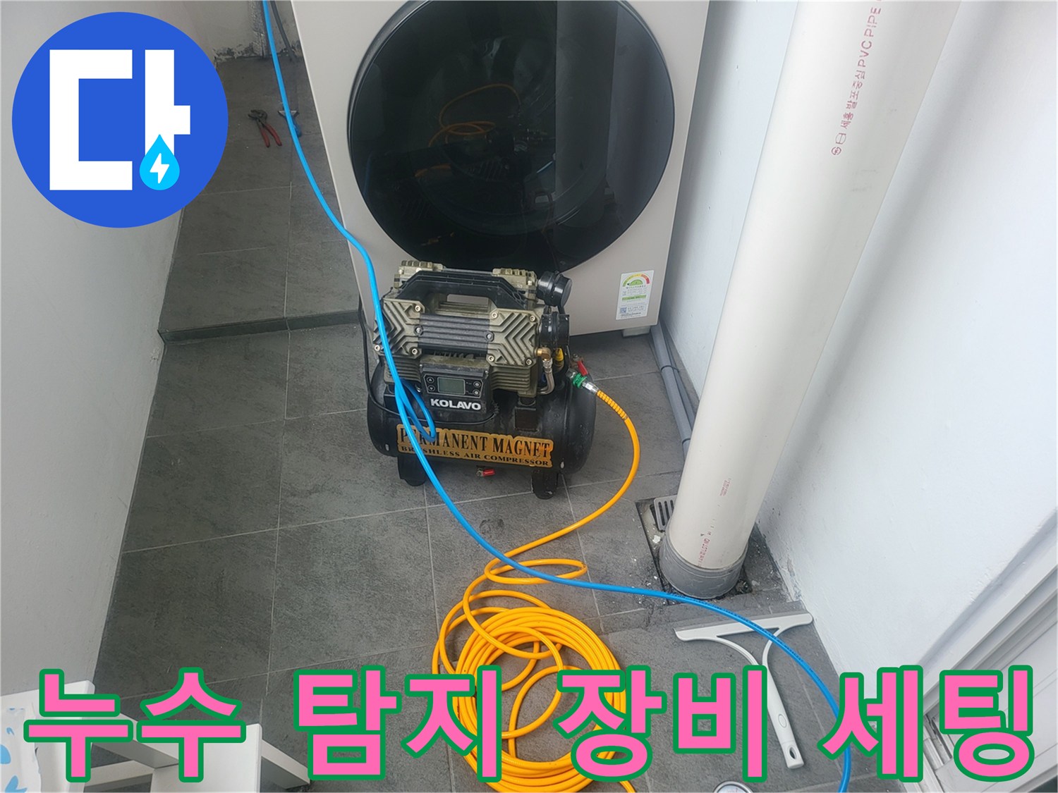 보일러 아래 공간에 설치된 배관 점검용 압력 게이지와 호스 연결 상태