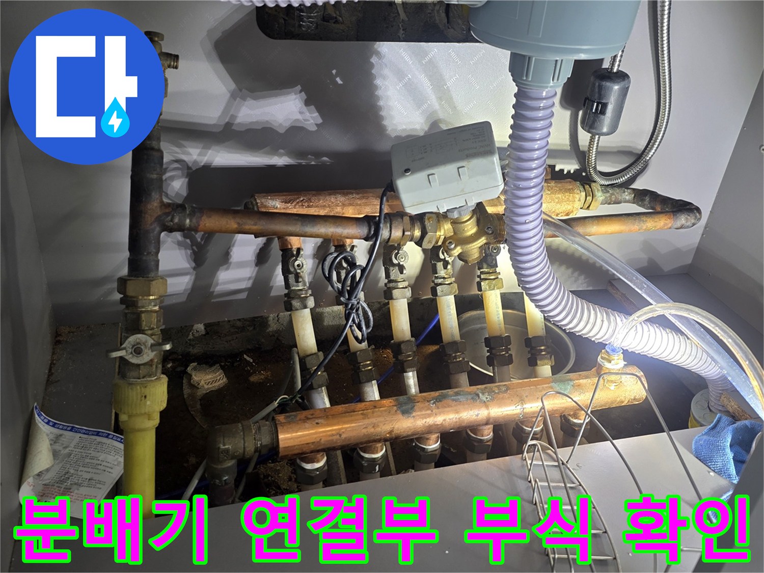 금속 분배기와 연결된 수도 배관의 노후화된 상태를 보여주는 사진