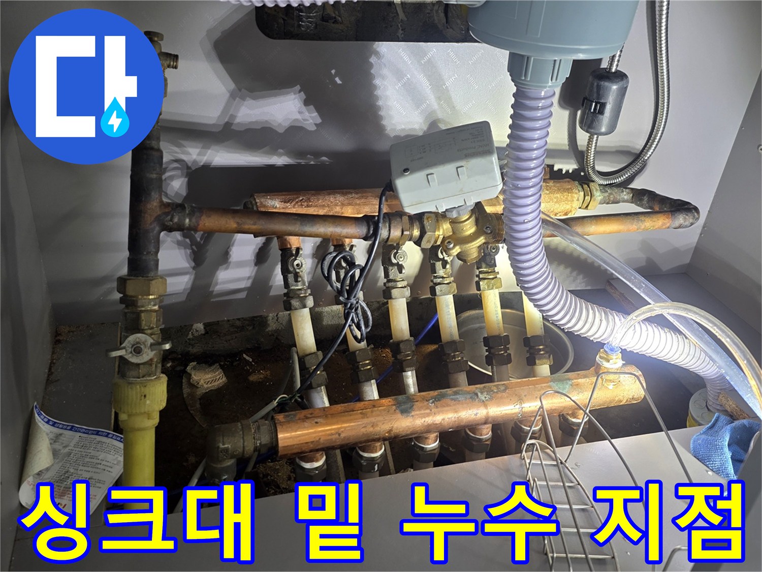 싱크대 하부장 내부의 노후된 보일러 분배기 배관 모습