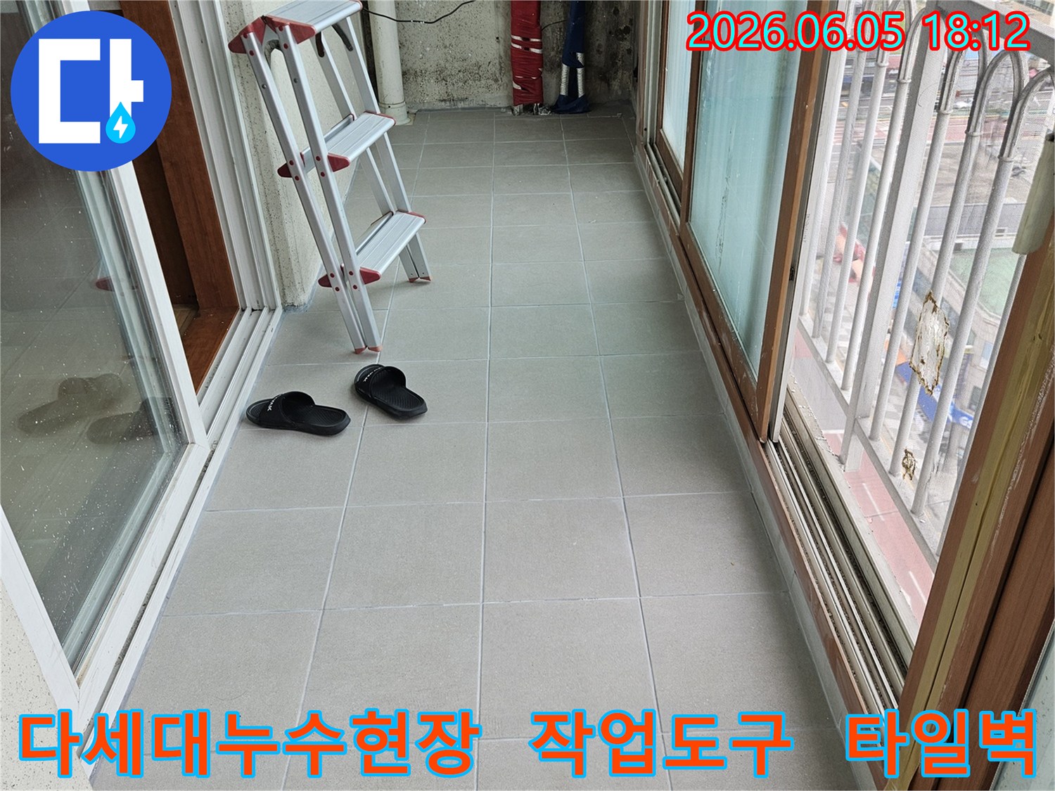 다세대-주택-베란다-누수-공사-현장에서-작업-도구와-함께-보이는-타일-벽면-및-창문-구조