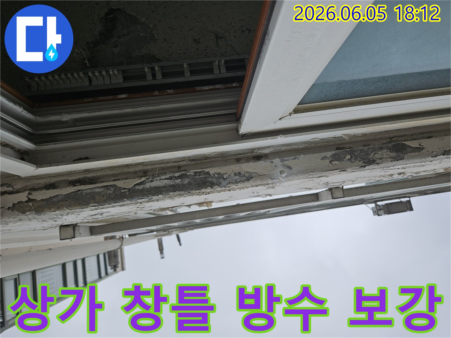 상가 건물 창틀 상단부의 오래된 페인트 손상-장마철 빗물 유입에 취약한 누수 흔적-장마철 대비를 위한 방수 보강 작업이 시급