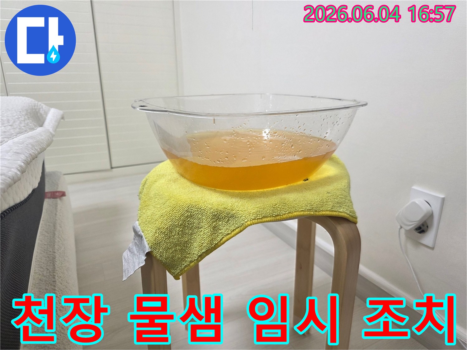 누수로 인해 천장에서 물이 떨어지는 상황에서-바닥과 가구의 손상을 방지하기 위해-설치된 임시 물받이의 모습