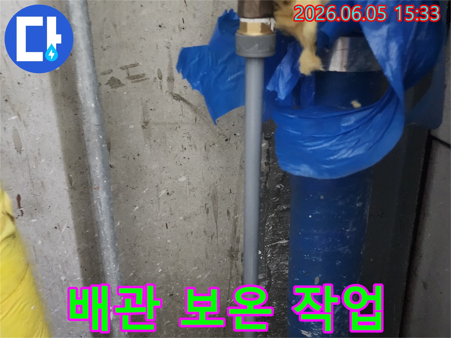 누수-배관-교체-작업이-완료된-후-결로-및-동파-방지를-위해-새로운-보온재로-배관을-감싸는-과정을-담은-사진입니다