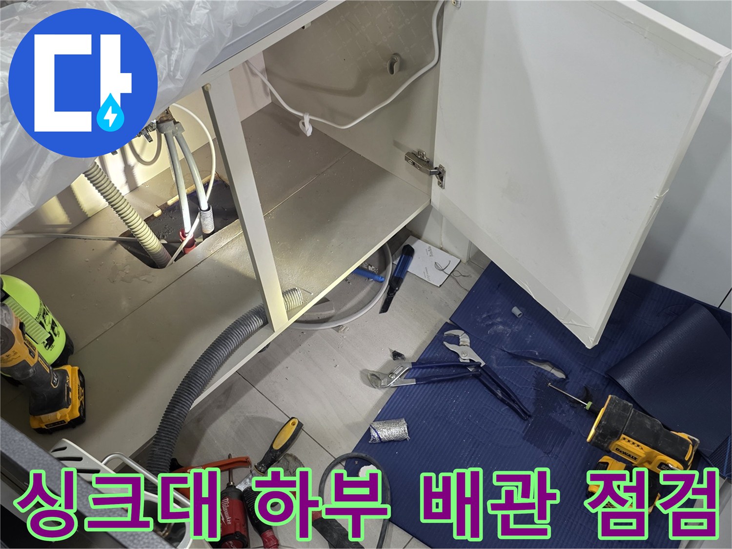 싱크대 아래쪽 배관과 수리용 전동 드릴의 배치