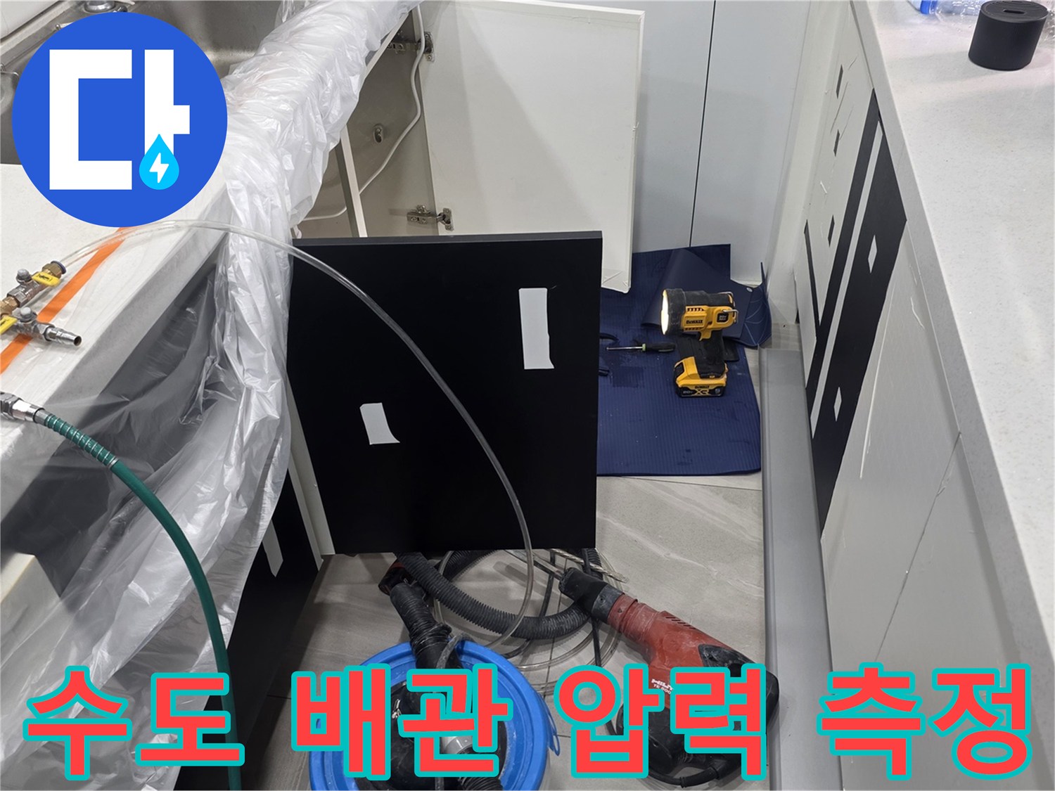 싱크대 하부 배관과 연결된 공압 테스트용 게이지와 호스