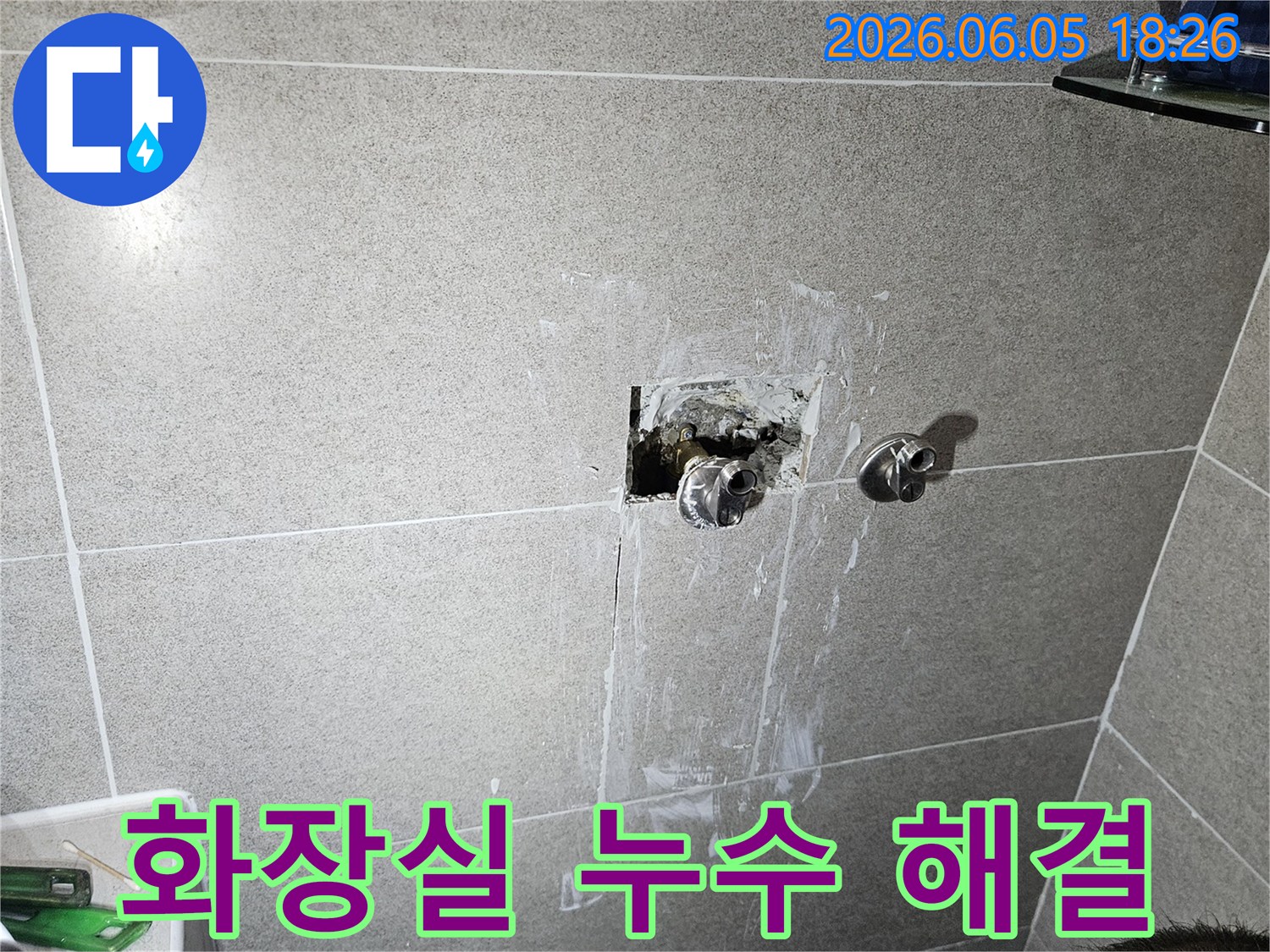 욕실 벽면의 누수 문제를 해결하기 위해-손상된 배관을 수리하고-타일 복구 준비를 하는 모습