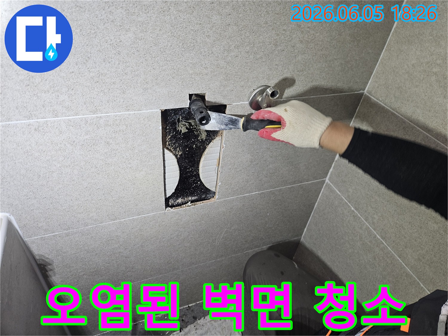 욕실 벽면의-누수 발생 부위를-확실하게 보수하기 위해-오염된 잔여물을-꼼꼼히 긁어내는-초기 작업 단계입니다.