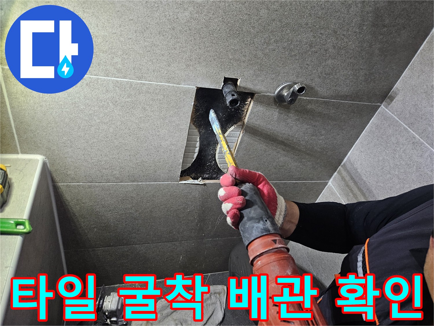전동 드릴로 타일을 제거하여 내부 매립 배관을 노출시킨 작업 사진