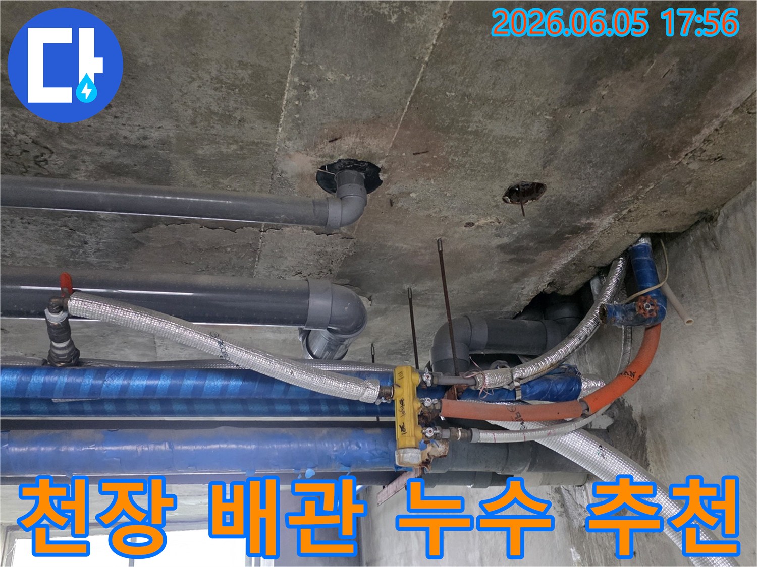 콘크리트-천장-아래-설치된-다양한-배관들의-복잡한-모습-누수-탐지-전문가가-현장을-면밀히-조사하고-있습니다