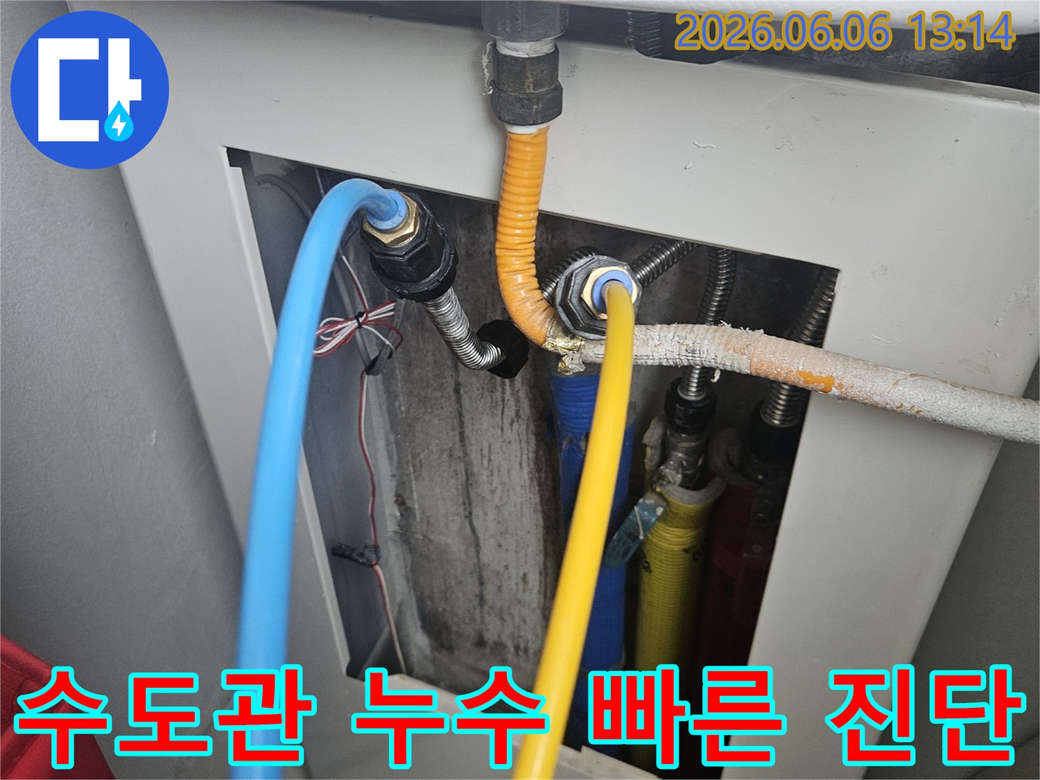 보일러 하단에 연결된 수도관의 연결 부위에서-누수 지점을 신속하게 진단하고 수리 준비를 하는 모습