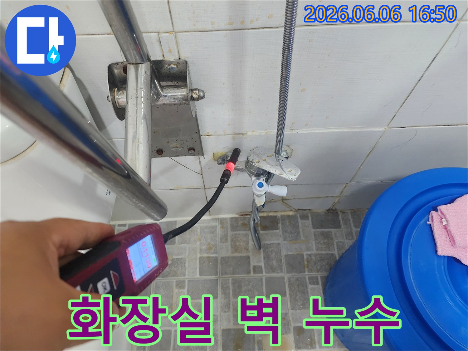 전문 엔지니어가-화장실 벽면의 수도 배관 누수 지점을-가스 탐지 장비로 정밀하게 분석하고 있습니다.