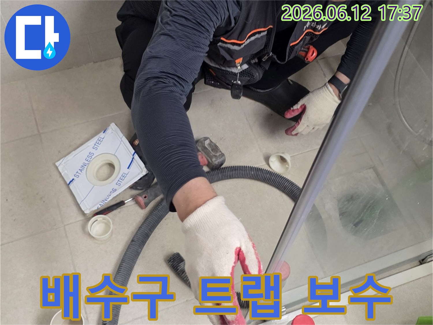 전문가가-욕실-배수구-트랩의-누수-여부를-점검하고-보수-또는-교체를-준비하는-모습