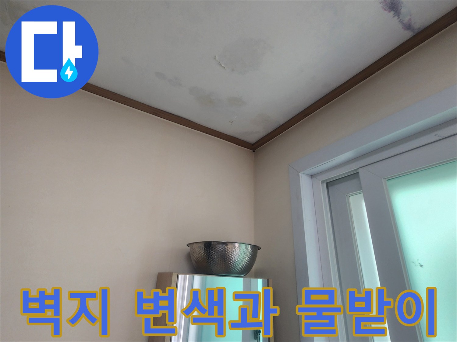 누수로 인해 벽지가 젖어있고-물이 떨어지는 것을 막기 위해-설치된 임시 물받이