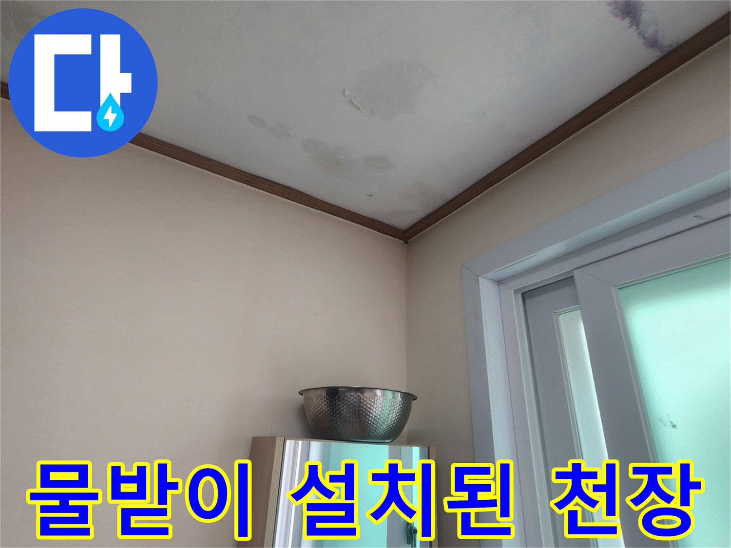 창문 근처에서 발생한 누수로-임시로 물을 받고 있는 상황을 보여주는 사진