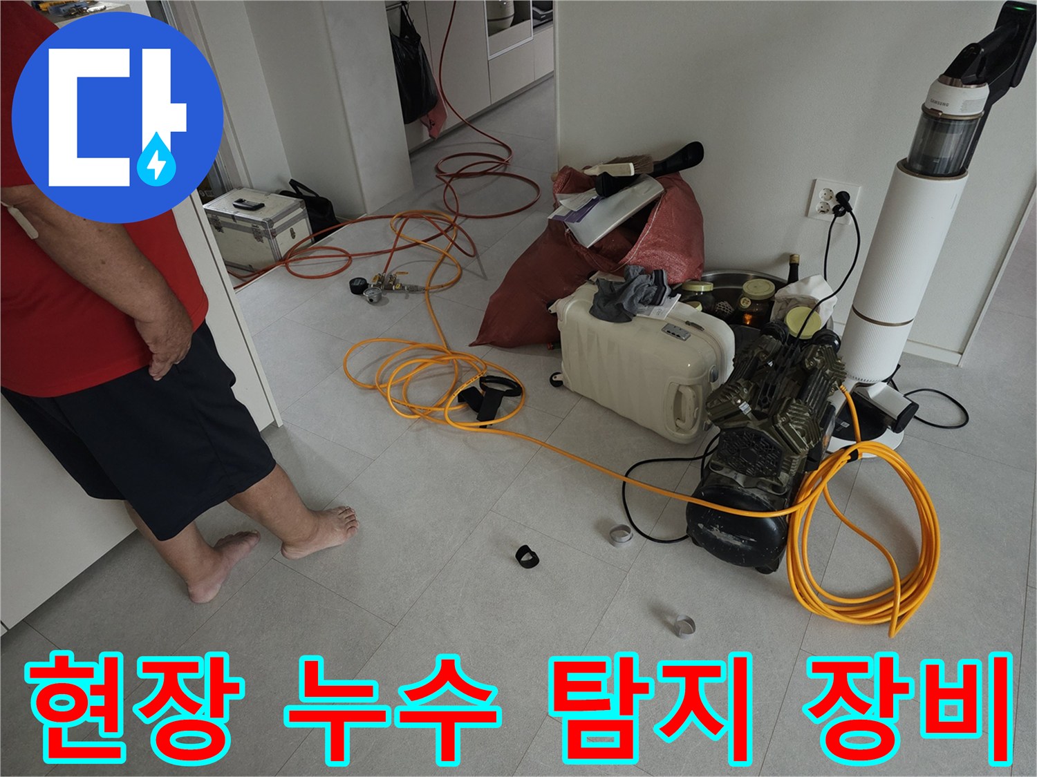 금천구 현장의 바닥 타일과 배치된 누수 검사용 호스 및 장비
