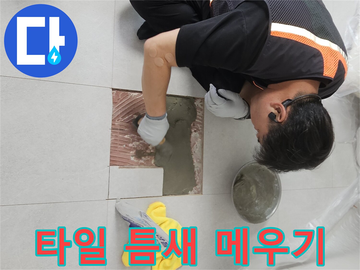 배관 수선 부위의 타일 사이를 시멘트로 채우는 장면