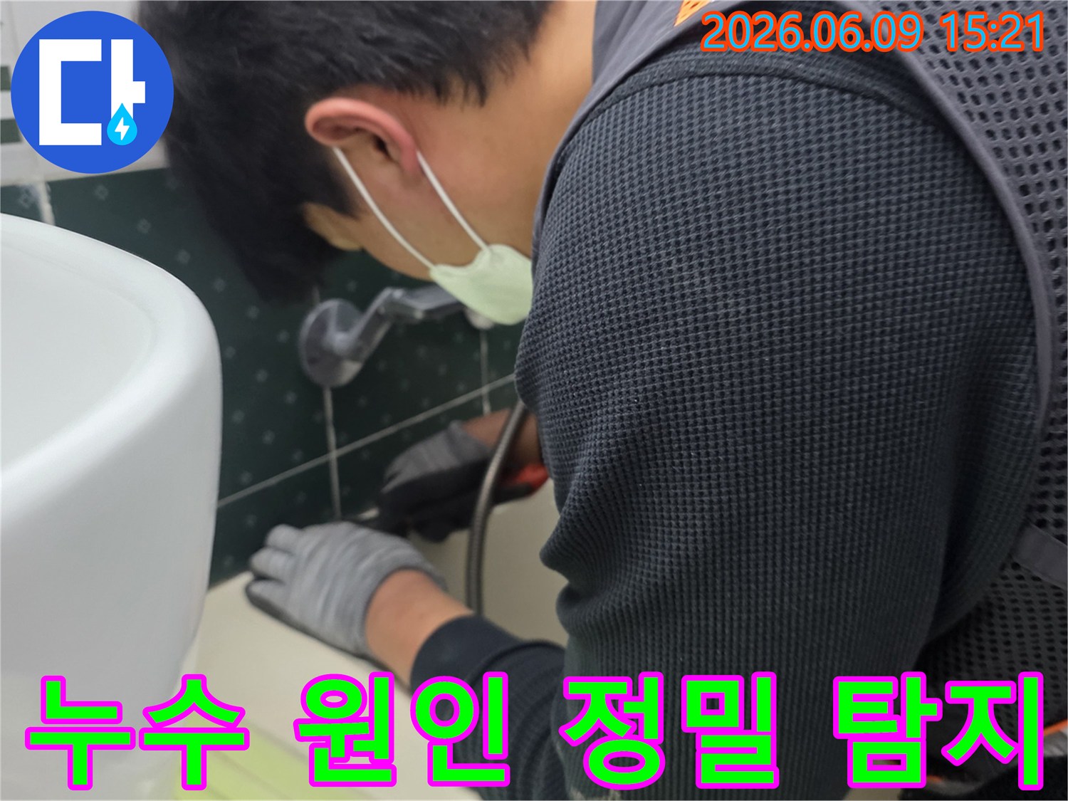 숙련된-누수-전문가가-마스크와-장갑을-착용하고-화장실-배관-주변을-정밀하게-탐지하며-누수-원인을-파악하는-모습입니다.