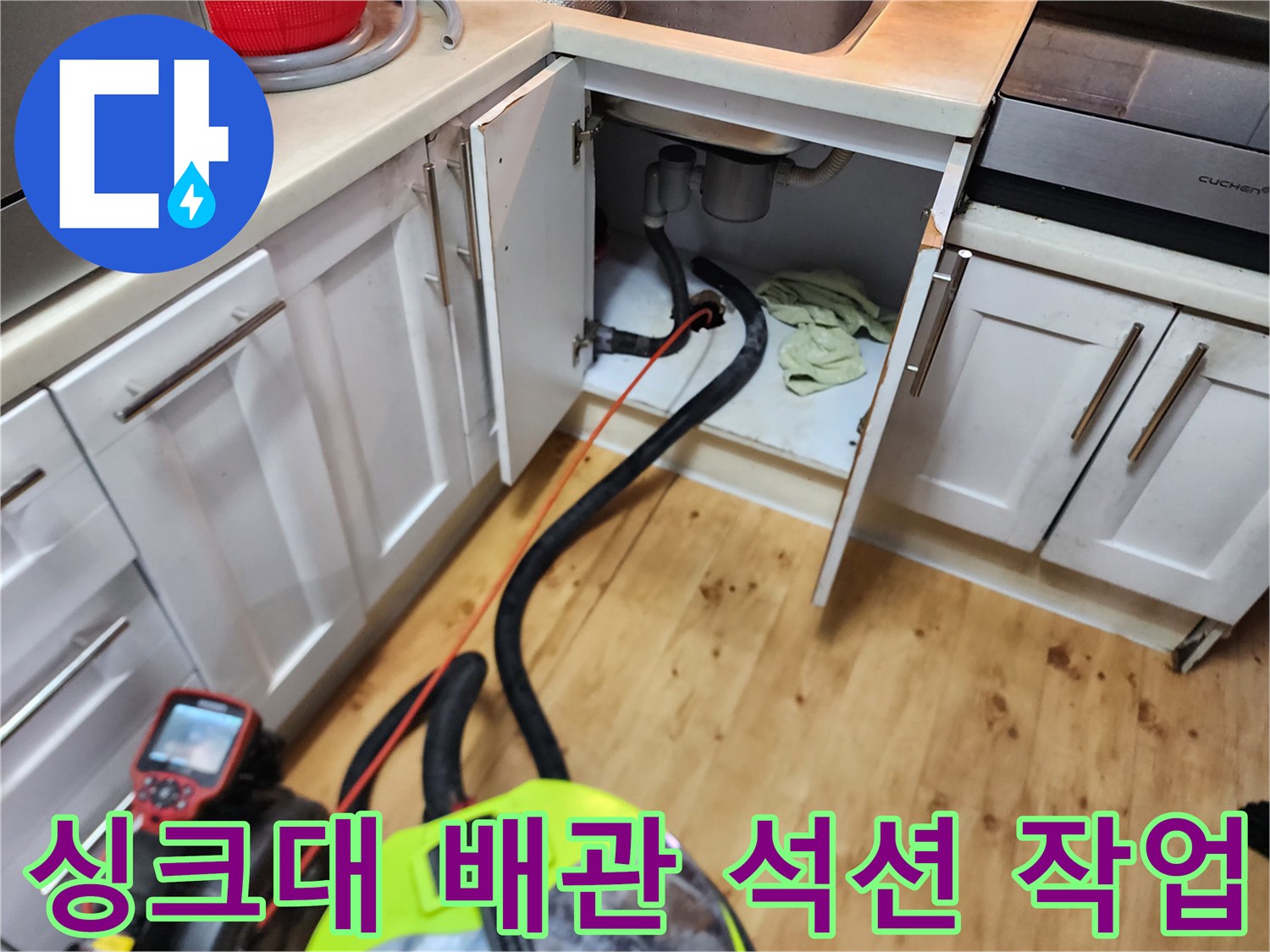 양천구 신정 신정동 싱크대 하부장 내부의 고인 물을 석션기로 흡입하는 장면