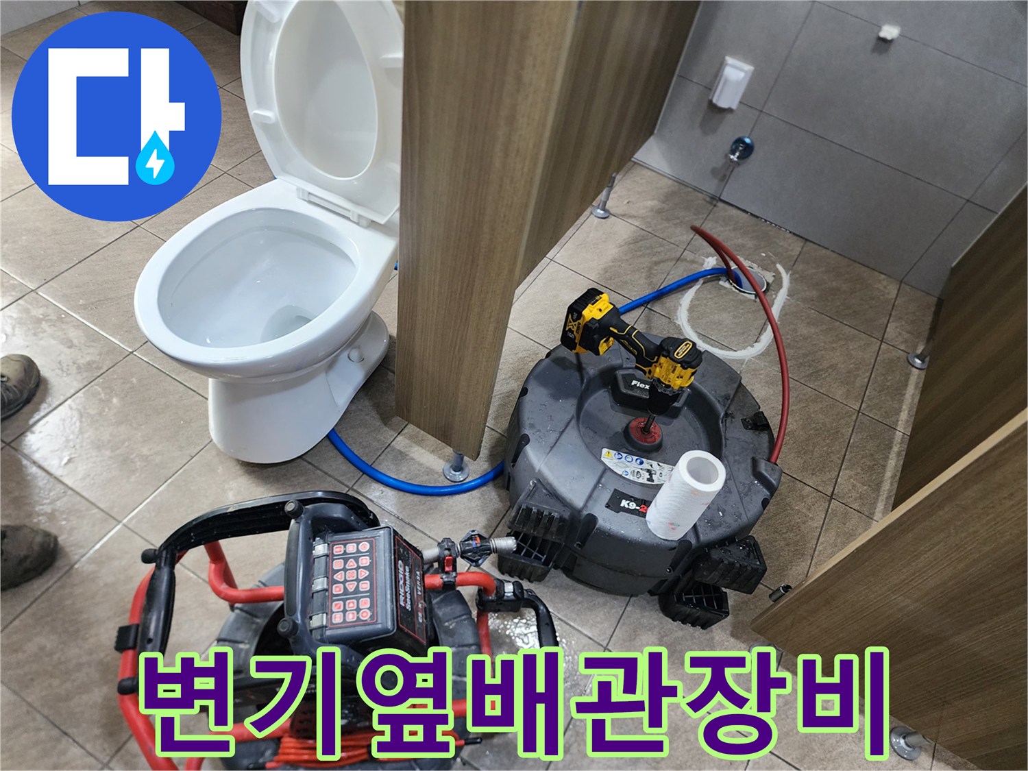 화장실 변기 옆에 배치된 배관 스케일링 장비와 샤프트 케이블