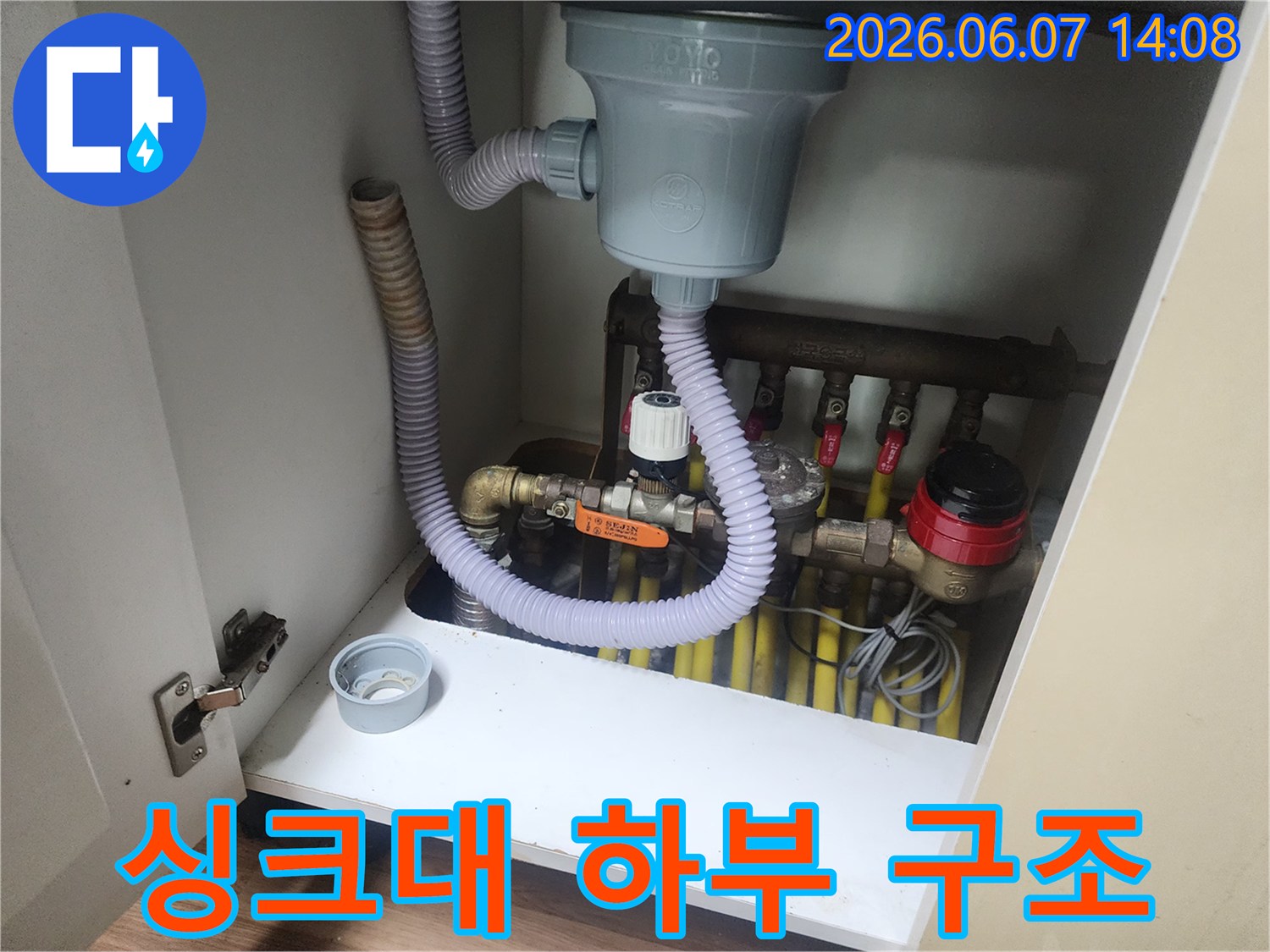 회색 주름관과 노형 배관-싱크대 밑에 설치된 배수 시스템의 모습입니다.