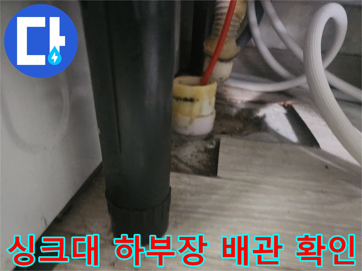 싱크대 하부의 복잡한 배관 구조와 내시연 장비가 투입된 현장 사진