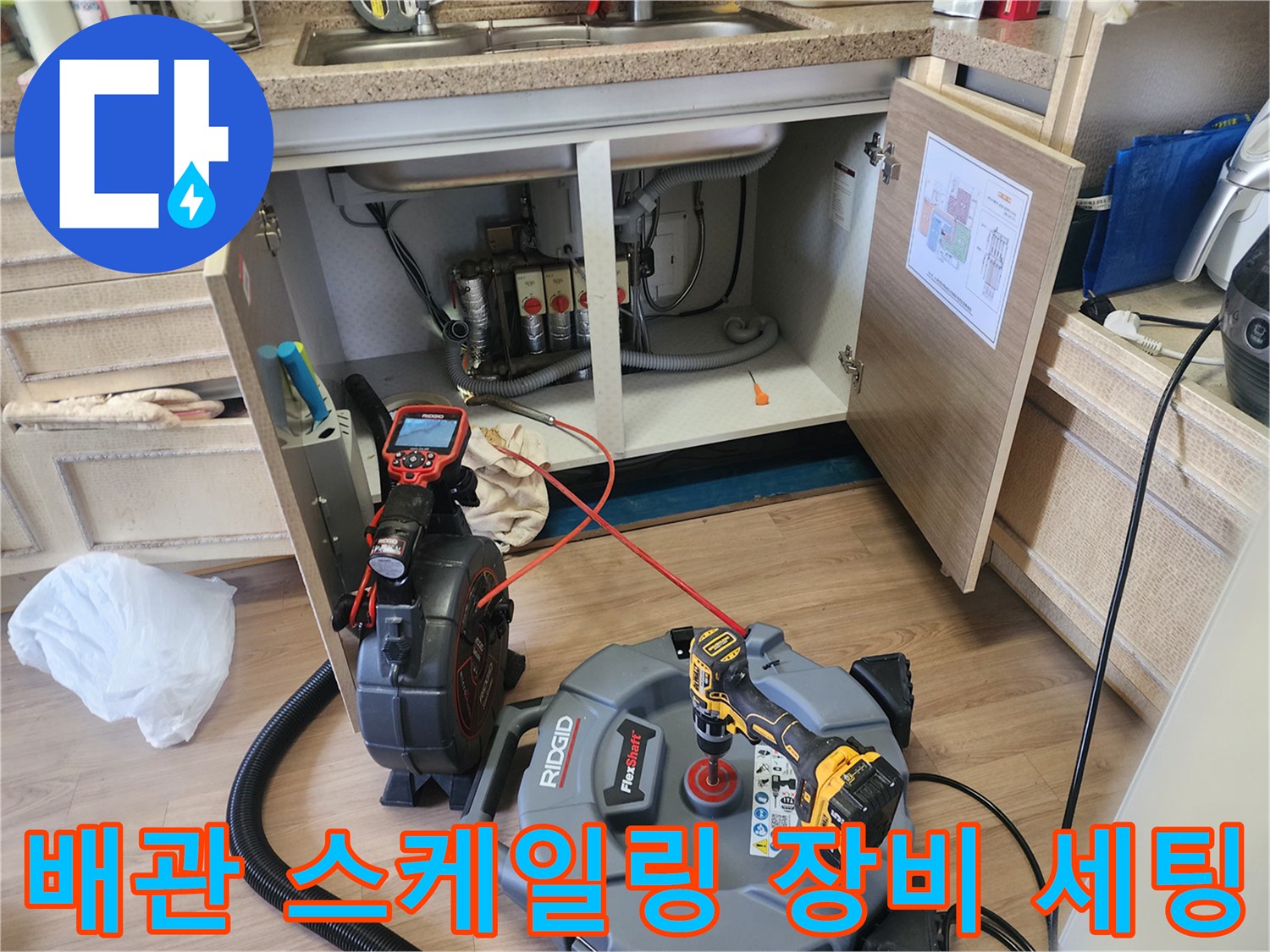 주방 싱크대 배관 청소를 위해 준비된 내시경 모니터와 석션기 호스