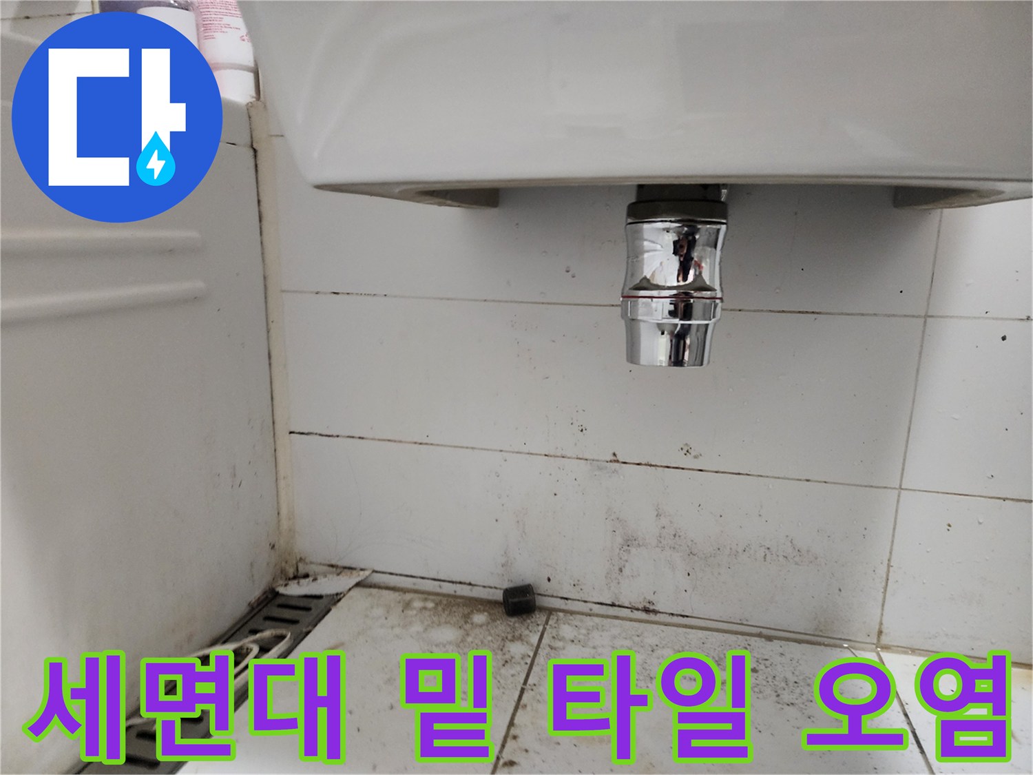 세면대 하부 배관 주변의 젖은 타일 표면 모습