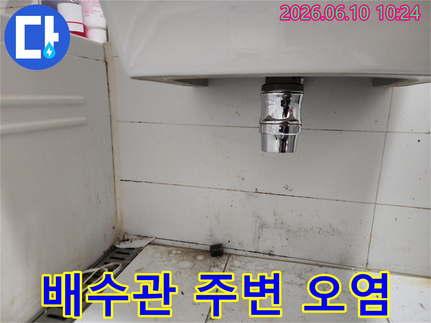 욕실 세면대 배수관 하부에서 발생한 물샘으로 인한 바닥 타일의 심각한 오염 상태