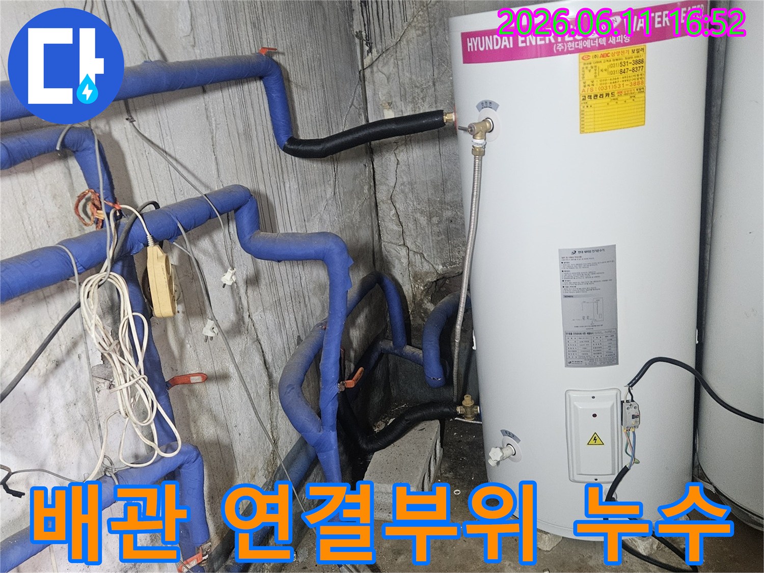 온수기-아래-배관의-연결-부위에서-발생한-누수를-정밀하게-점검하는-모습입니다.