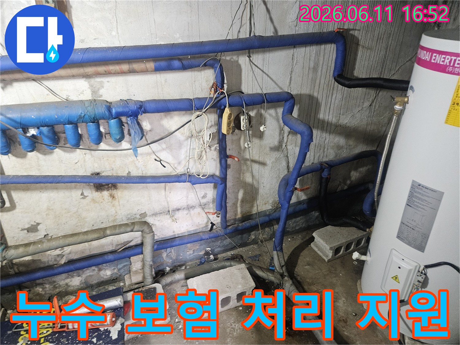 파란색 보온재 배관들과-누수 흔적이 보이는-아파트 현장에서-보험 처리를 위한-서류 작업을 진행 중입니다