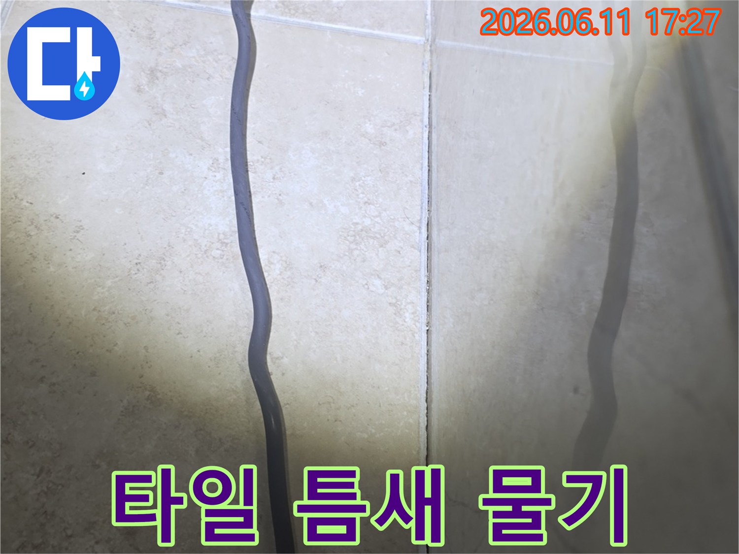 욕실 타일 틈새로 물이 스며들어-벽면에 습기가 올라온 현장을 보여주는 사진입니다