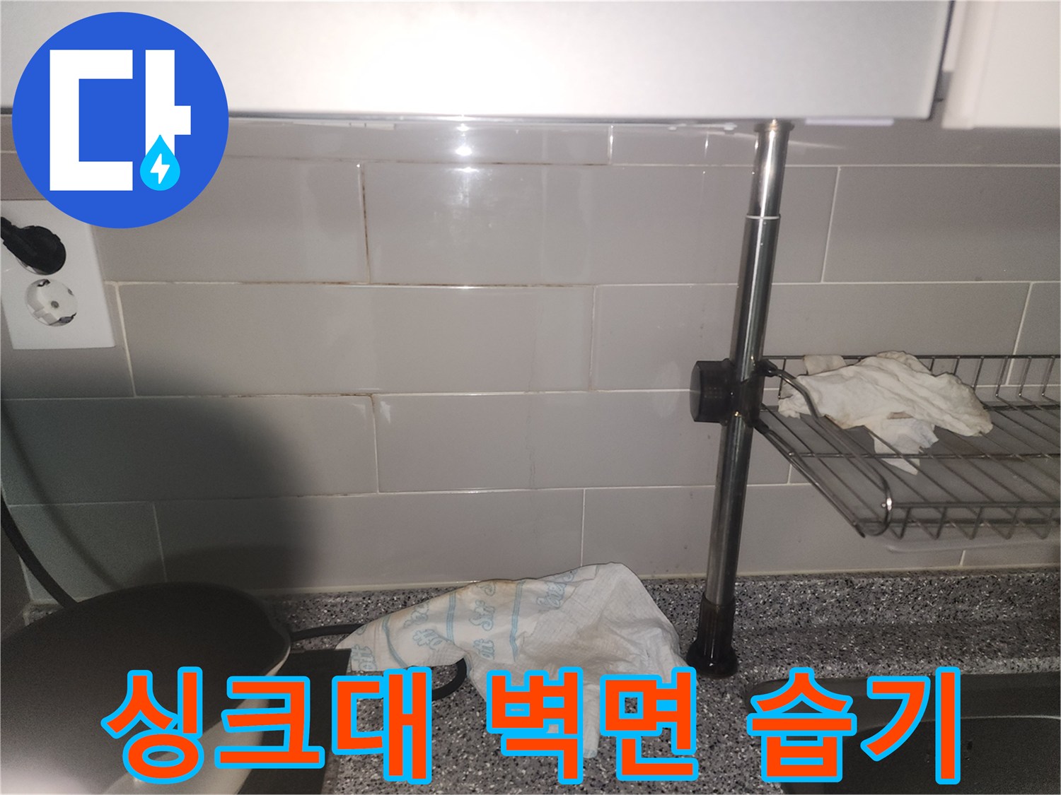 싱크대 주변 타일 벽면에-습기가 스며들어-젖어있는 모습이 포착된 사진