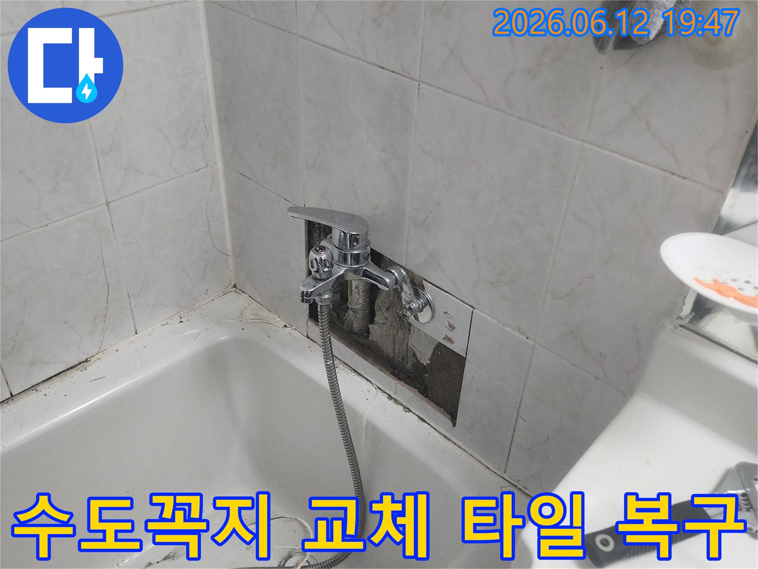 욕실 벽면의 타일이 제거된-상태에서-새로운 수도꼭지가-설치되고-타일 복구 작업이-진행되는-모습을-담은-사진입니다.