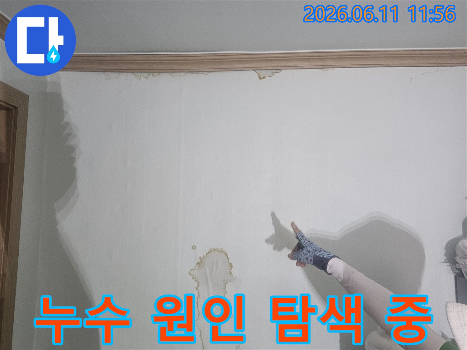 벽지 위로-번져나간-물 얼룩을-정밀하게-관찰하고-있는-누수 진단-사진입니다
