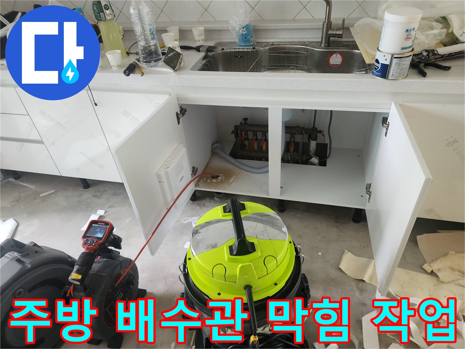 싱크대 아래쪽의 막힌 배관을 청소하기 위한 장비 세팅 상태