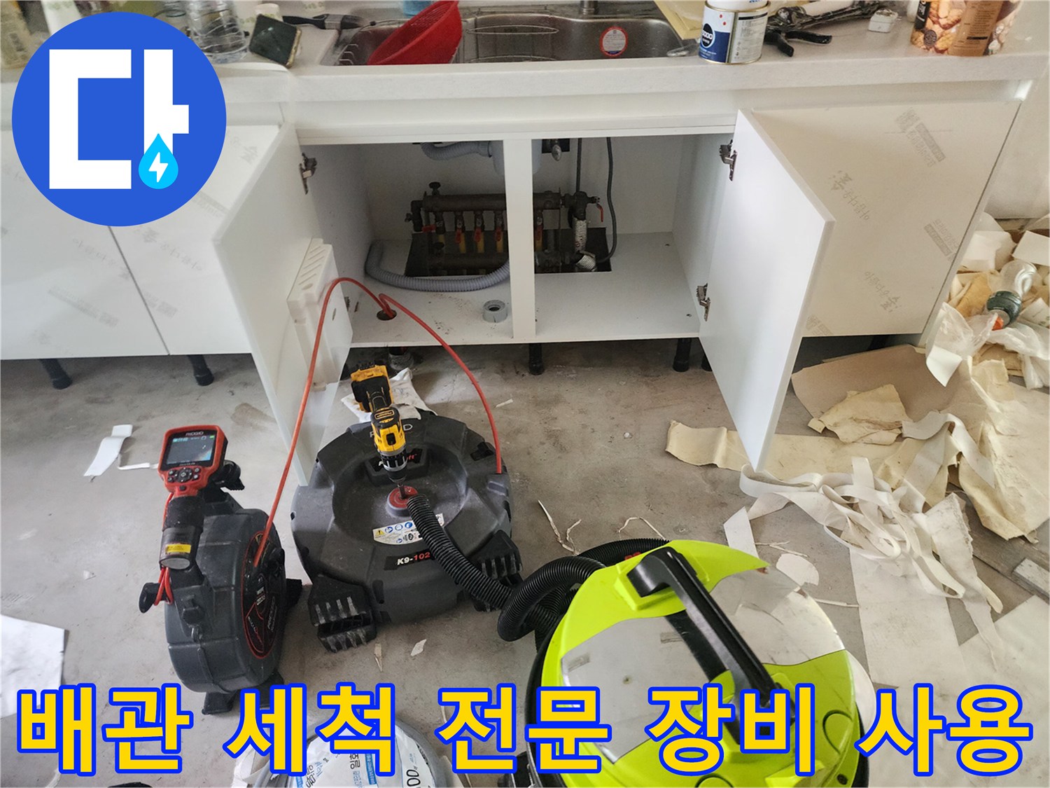 주방 싱크대 아래-배관 청소를 위해 가동 중인 석션기와 내시관계측기