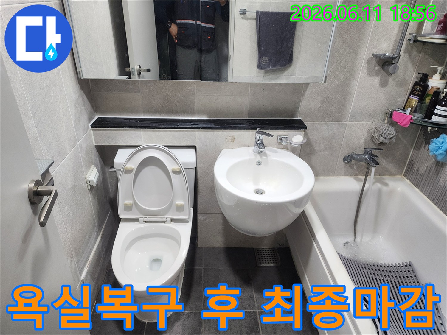 누수-수선-후-타일-마감과-변기-세면대-설치가-완료되어-새로운-모습으로-변모한-욕실의-전경을-보여줍니다