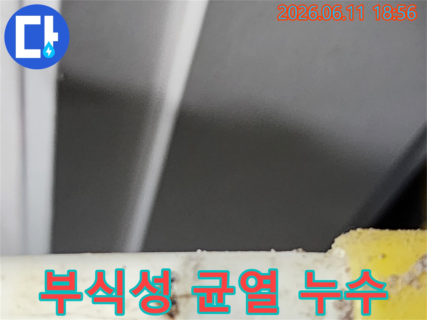오래된 아파트 배관에서 발생한-부식성 균열로 인한 누수 지점을-전문가가 정확하게 확인한 모습입니다.