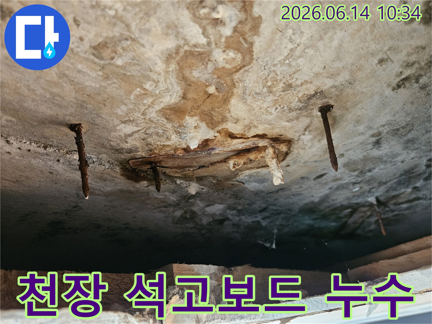 천장 석고보드가 물에 젖어-손상되고-녹슨 못이 드러난-누수 피해 현장입니다.