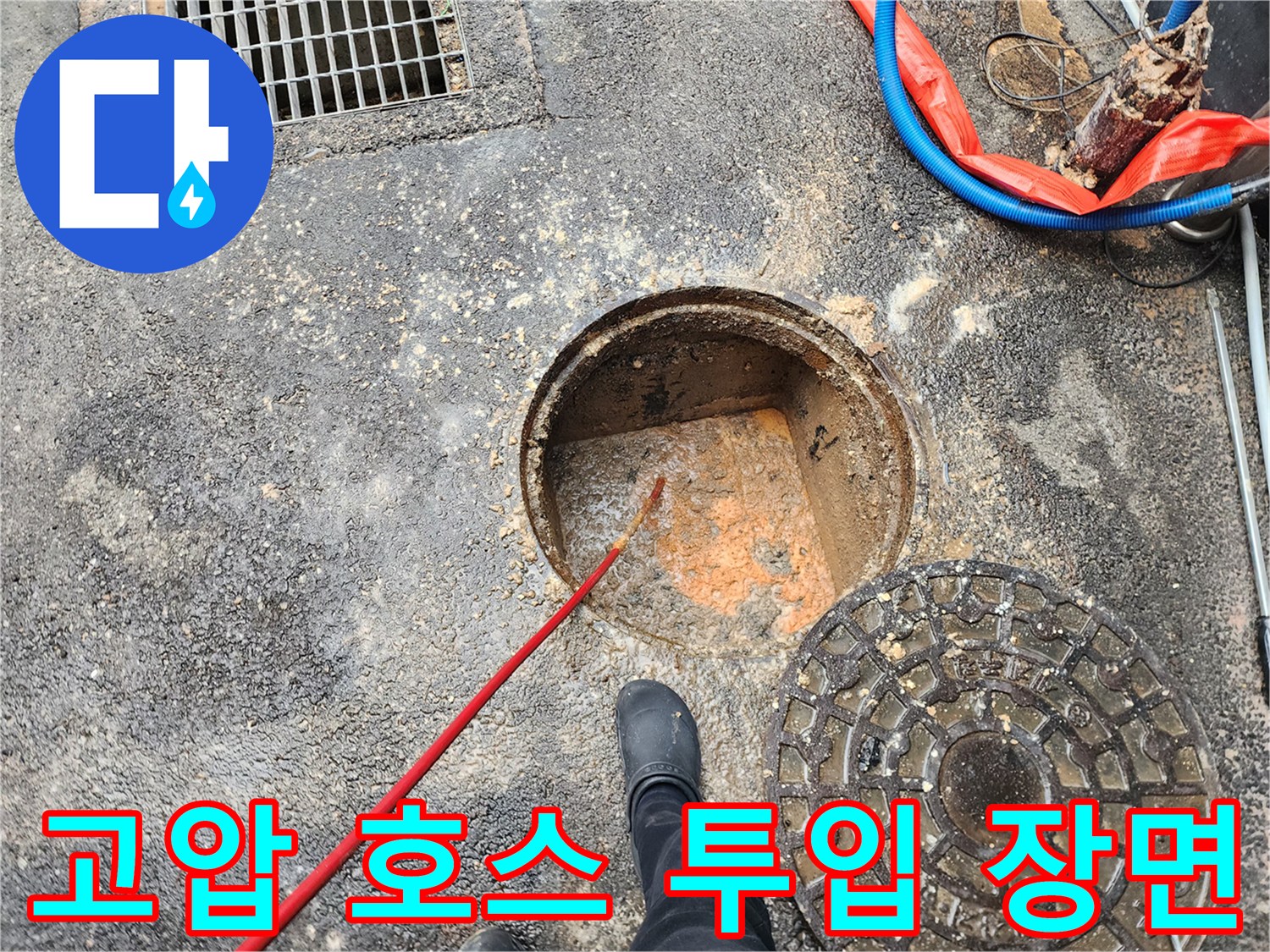 배관 내부 세척을 위해-고압 호스를 맨홀 안으로 밀어 넣는 모습입니다