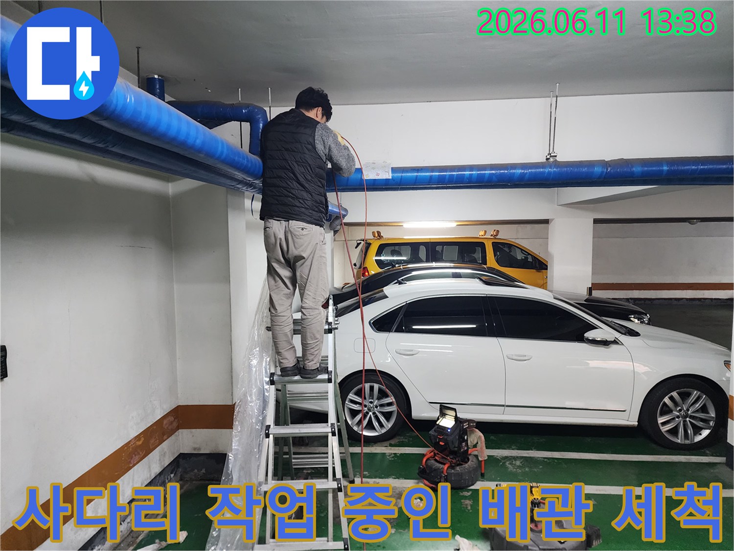 천장 파란색 배관을 대상으로 진행되는 고압 세충 작업 모습
