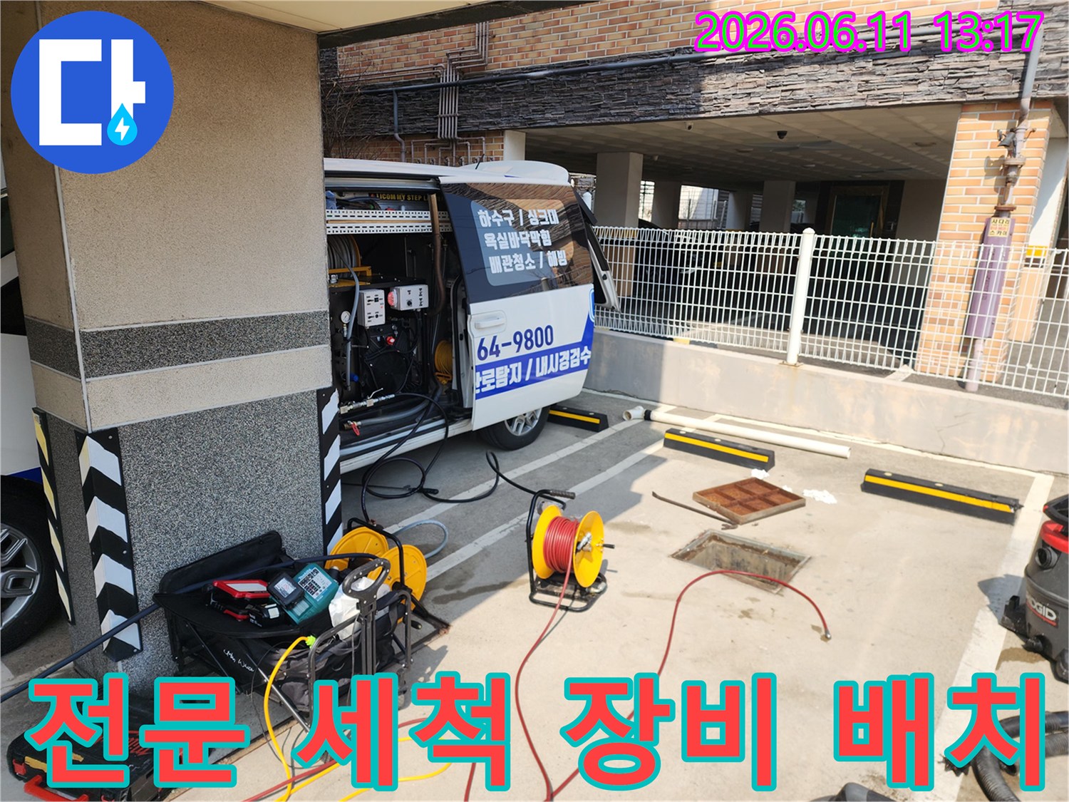 맨홀 작업 부근에 준비된 고압 세척기와 호스 릴