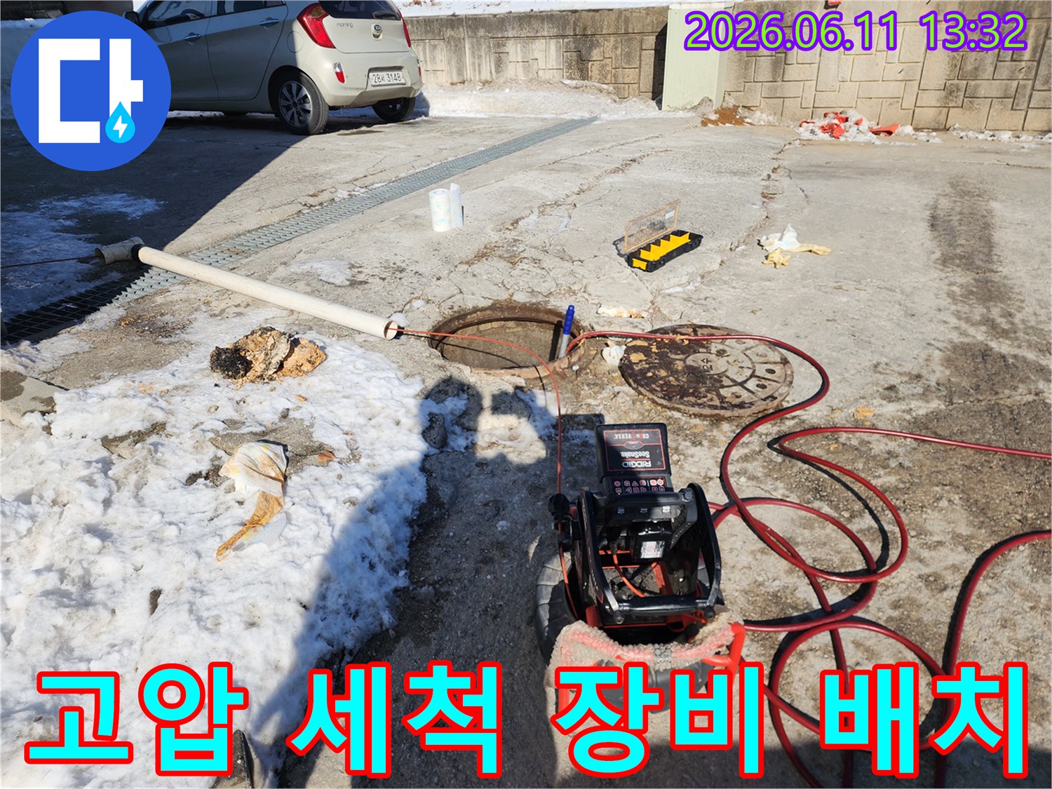 야외 맨홀 근처-배관 청소를 위해 설치된 고압 세척기 모니터와 호스