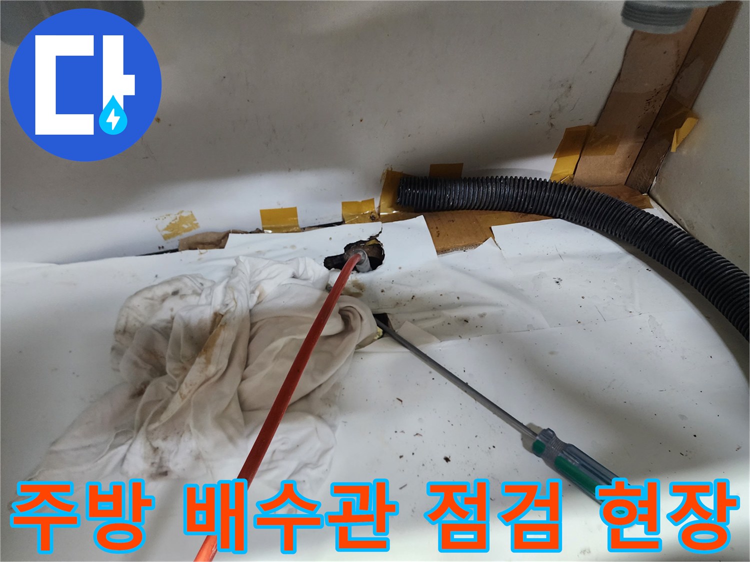 싱크대 아래쪽 좁은 공간에서 진행되는 배관 내부 세척 작업 모습