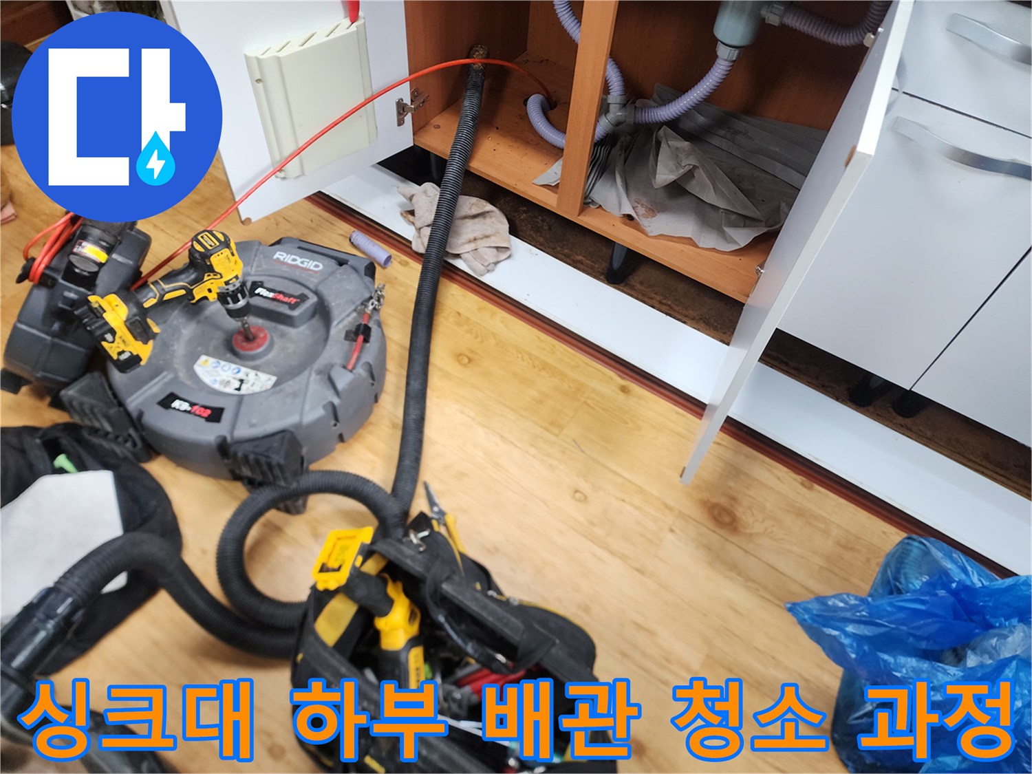 중곡동 현장 싱크대 아래쪽에서 진행 중인 배관 스케일링 장비와 호스 연결 상태